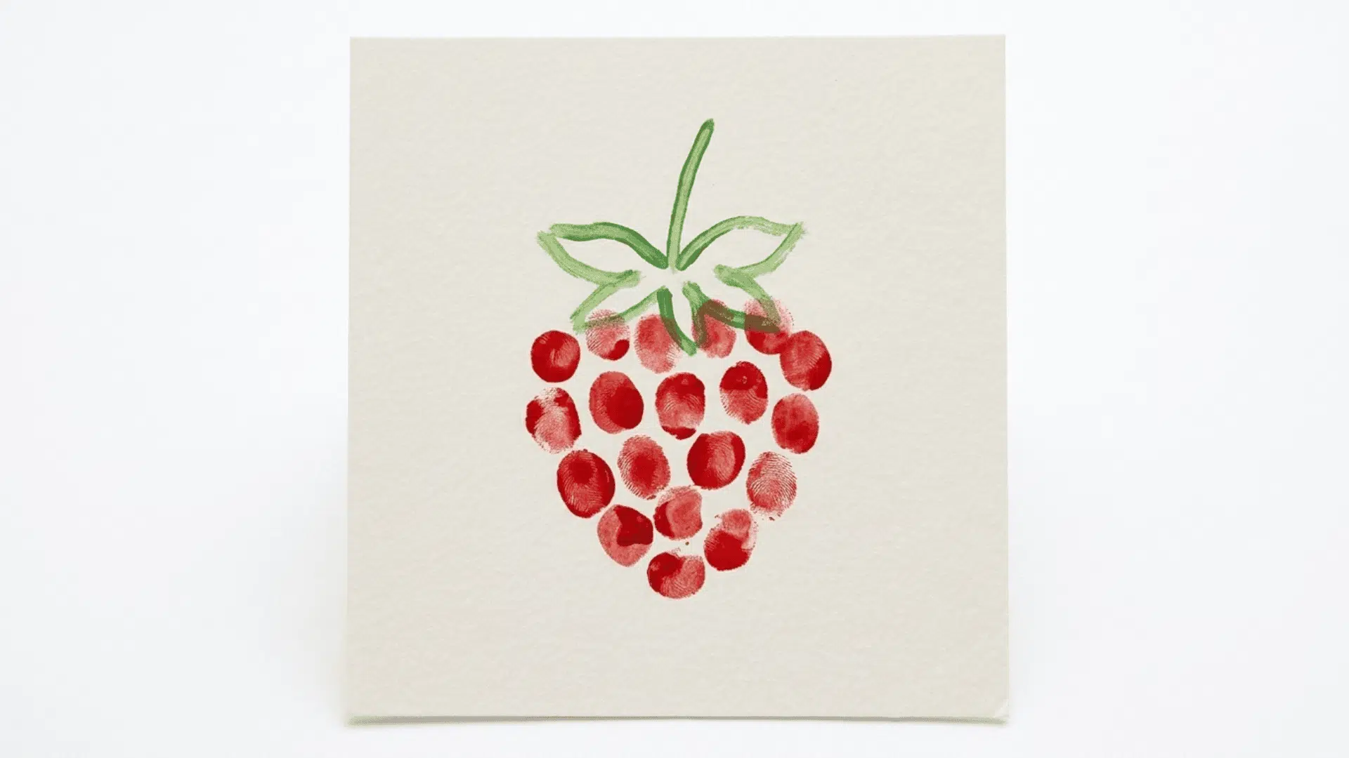 fingerprint strawberry art showing red fingerprint dots forming a strawberry shape with green painted leaf lines on paper