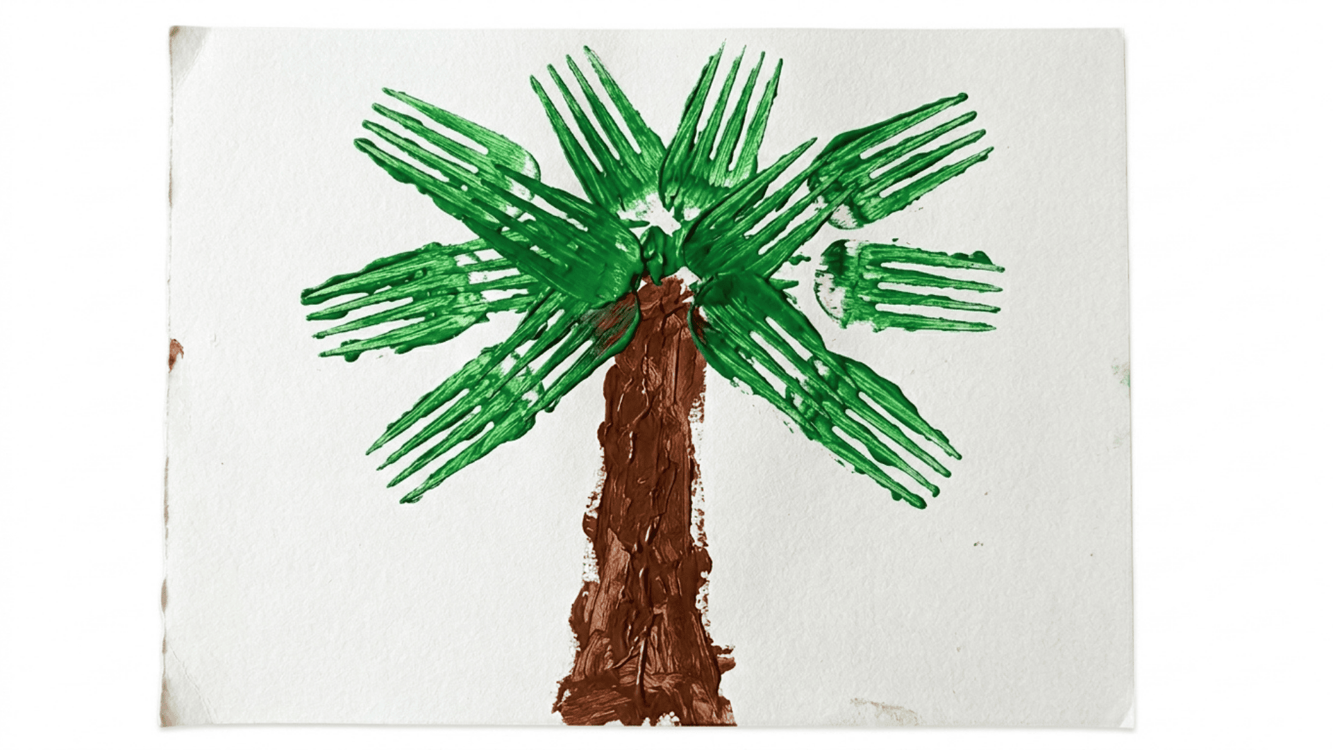 fork painted palm tree artwork showing green fork print leaves and a brown painted trunk on white paper for kids