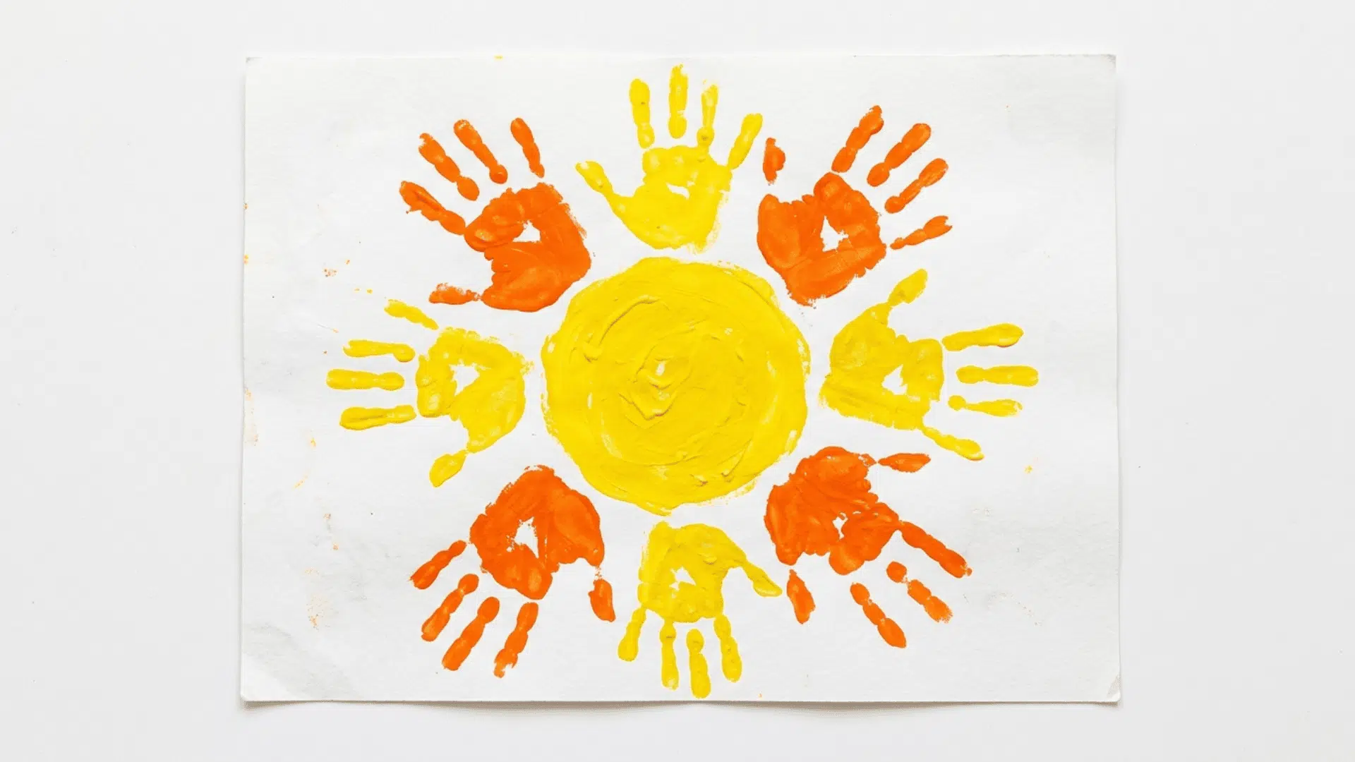 handprint sun art painting with orange and yellow painted handprints forming sun rays on white paper for kids