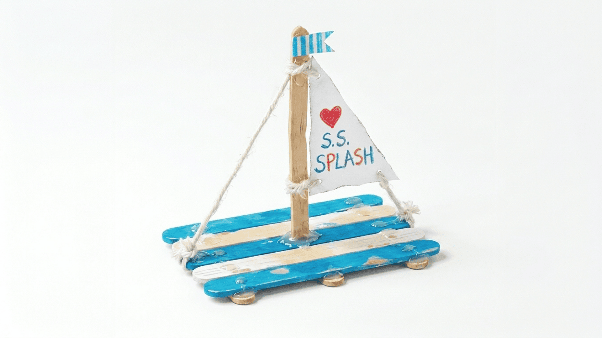 popsicle stick sailboat craft showing flat sticks glued as a boat base with a paper triangle sail on a stick mast above