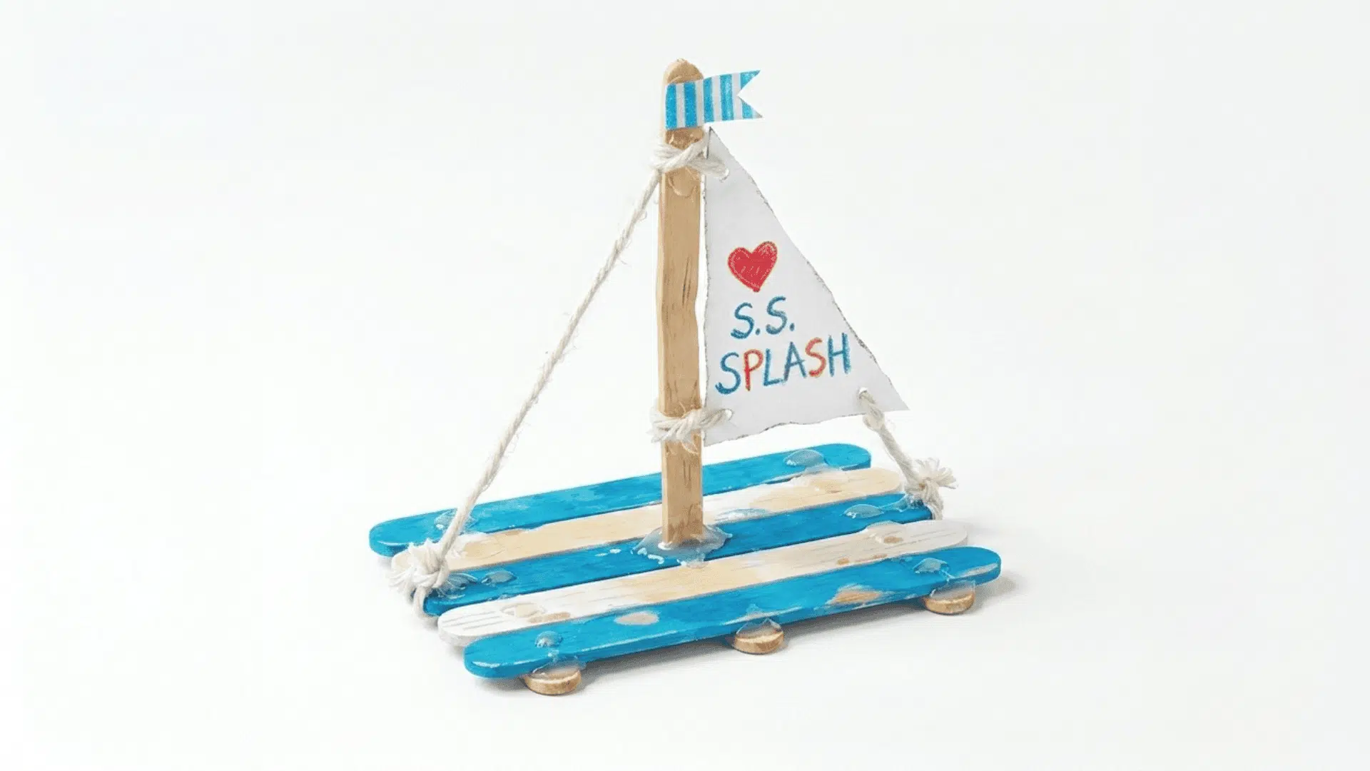 popsicle stick sailboat craft showing flat sticks glued as a boat base with a paper triangle sail on a stick mast above