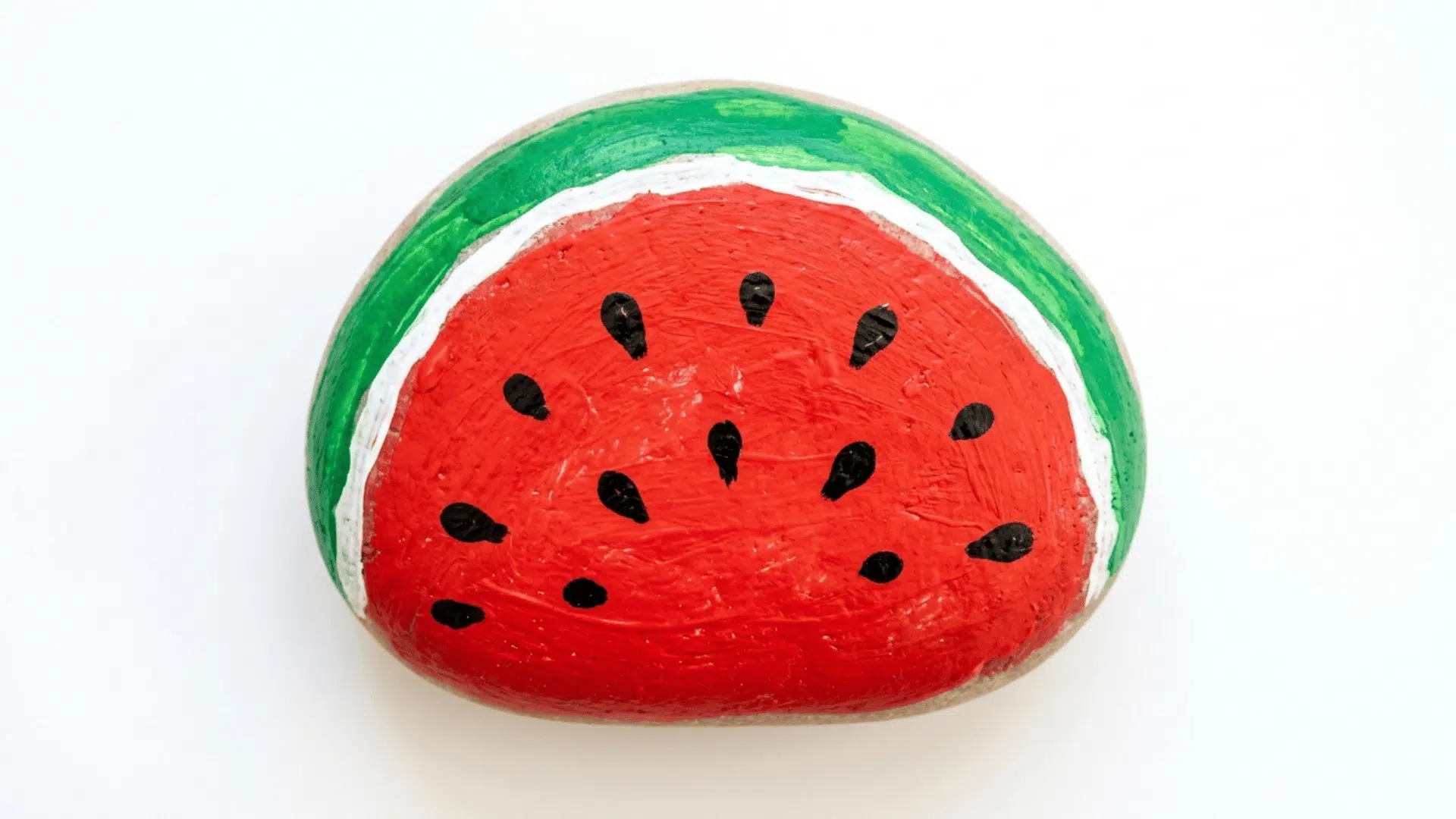 rock painting with summer signs showing a smooth stone decorated with a bright watermelon slice in red green and black paint