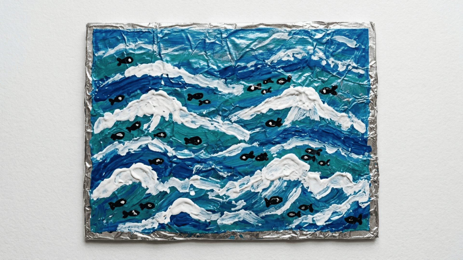 tin foil ocean painting showing crinkled foil cardboard painted with deep blue teal and white wave strokes with small black fish shapes