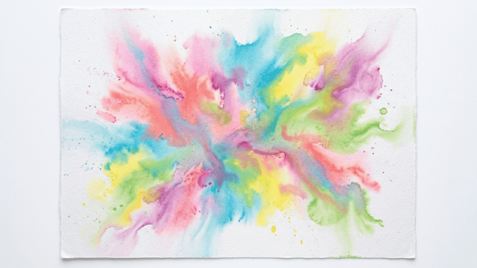 water spray chalk art showing soft blended streaks of pink blue yellow and green chalk colors spreading across white paper
