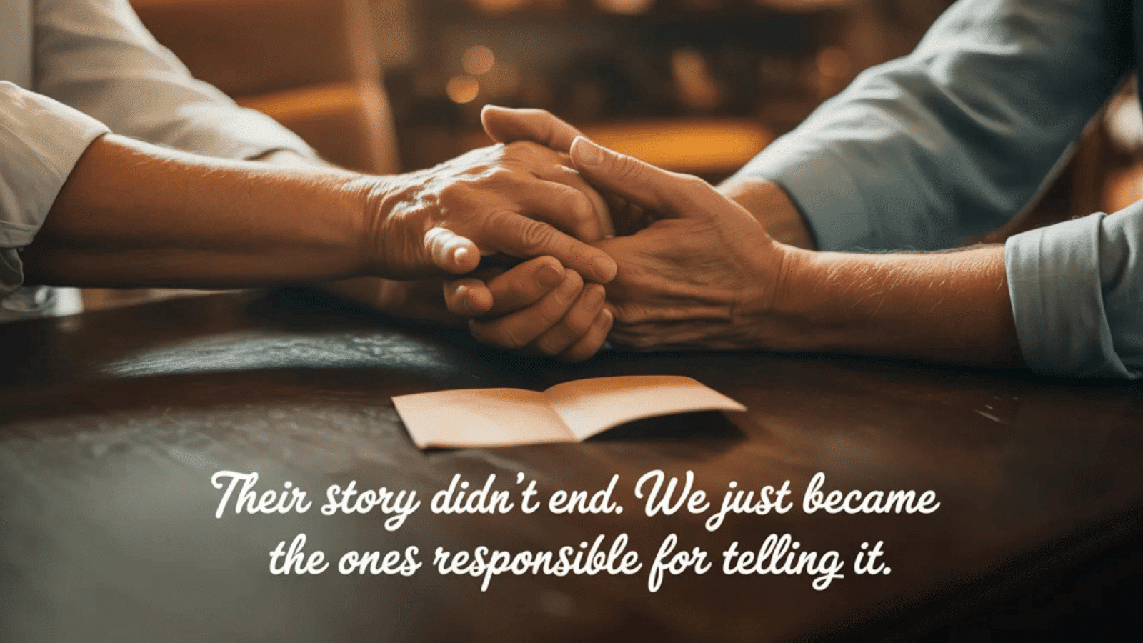 close-up of hands holding in comfort over a table, symbolizing remembrance, legacy, and responsibility to honor their story