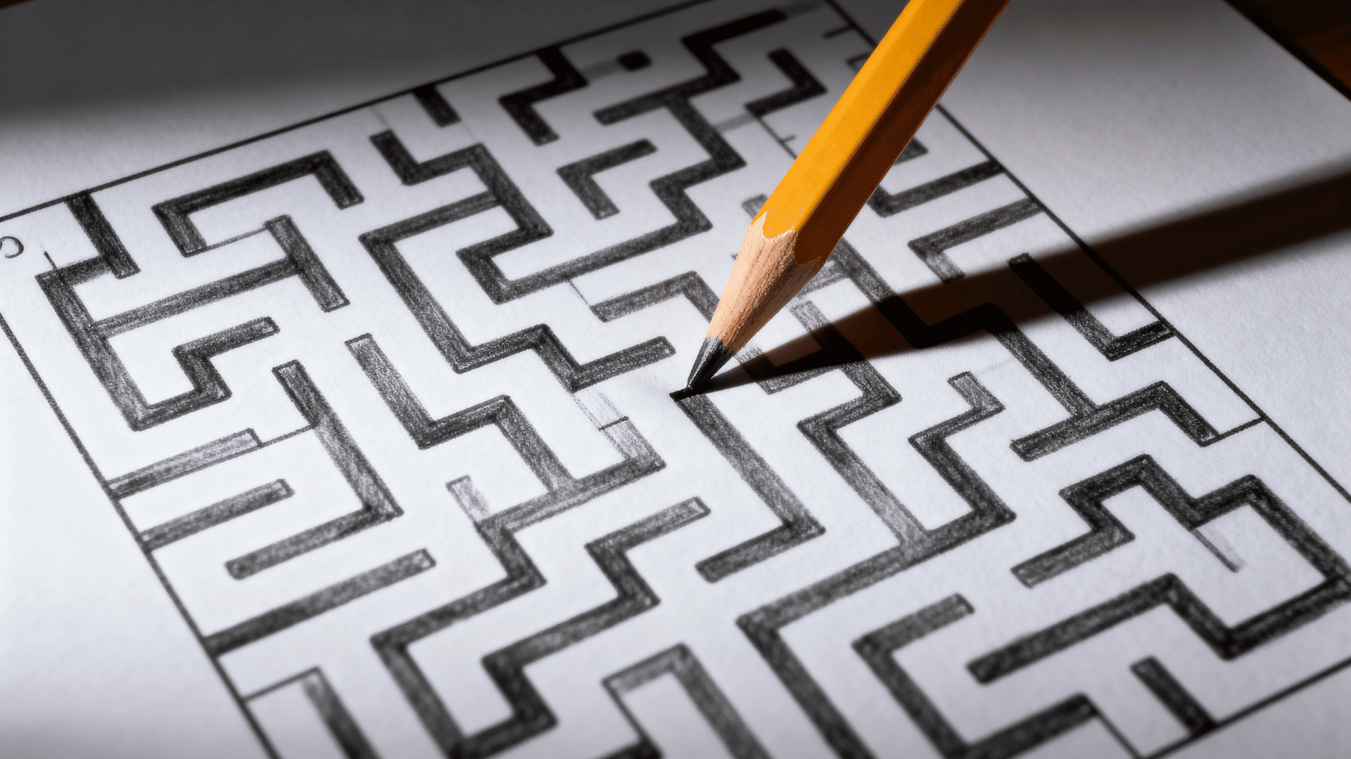 Hand-drawn maze puzzle with winding paths and dead ends on white paper.