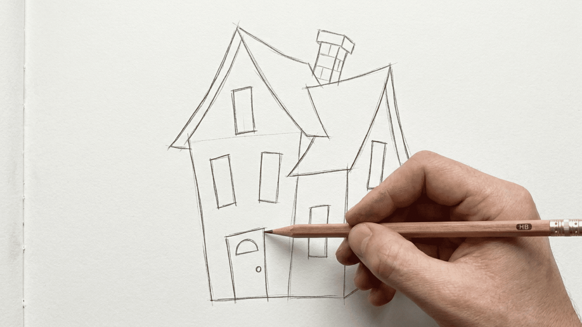 hand drawing an easy haunted house sketch with crooked roof and spooky windows on paper.