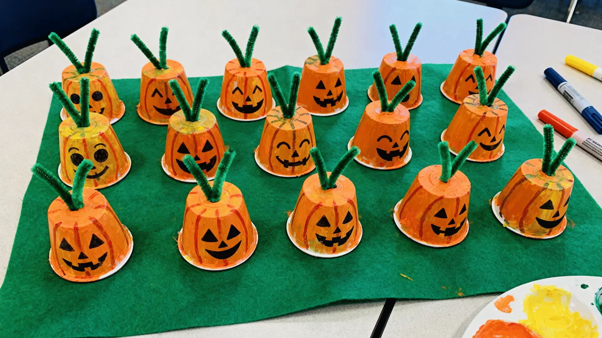 egg carton pumpkin patch craft with painted pumpkin faces and pipe cleaner stems