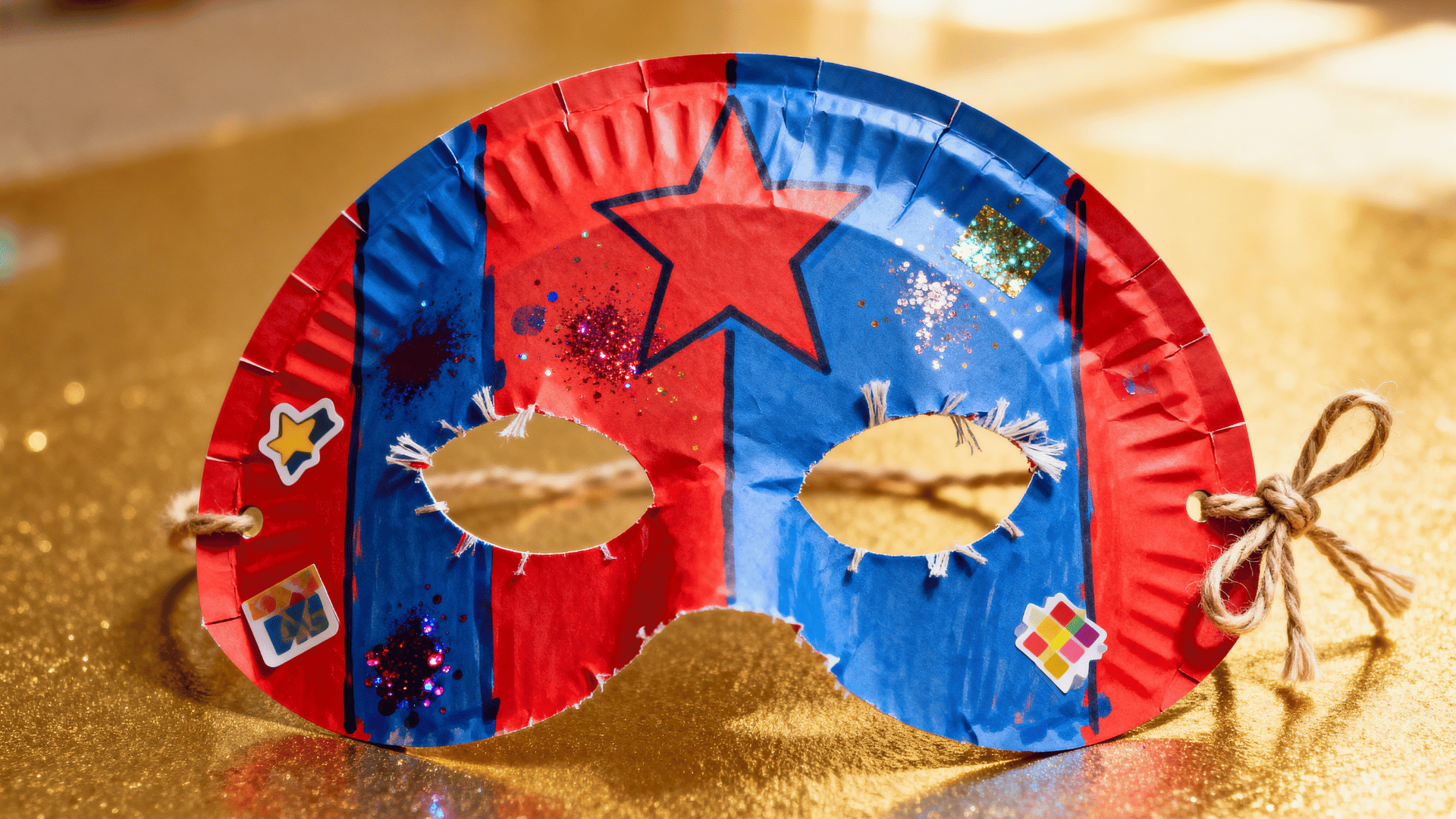 paper plate superhero mask decorated by a toddler with colorful drawings and markers.