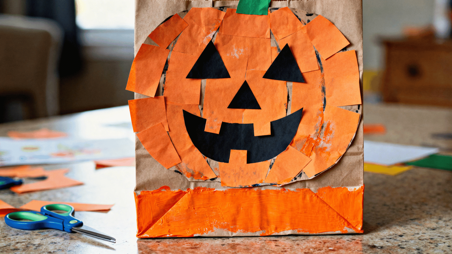 paper bag pumpkin puppet decorated with orange paper and a jack-o'-lantern face