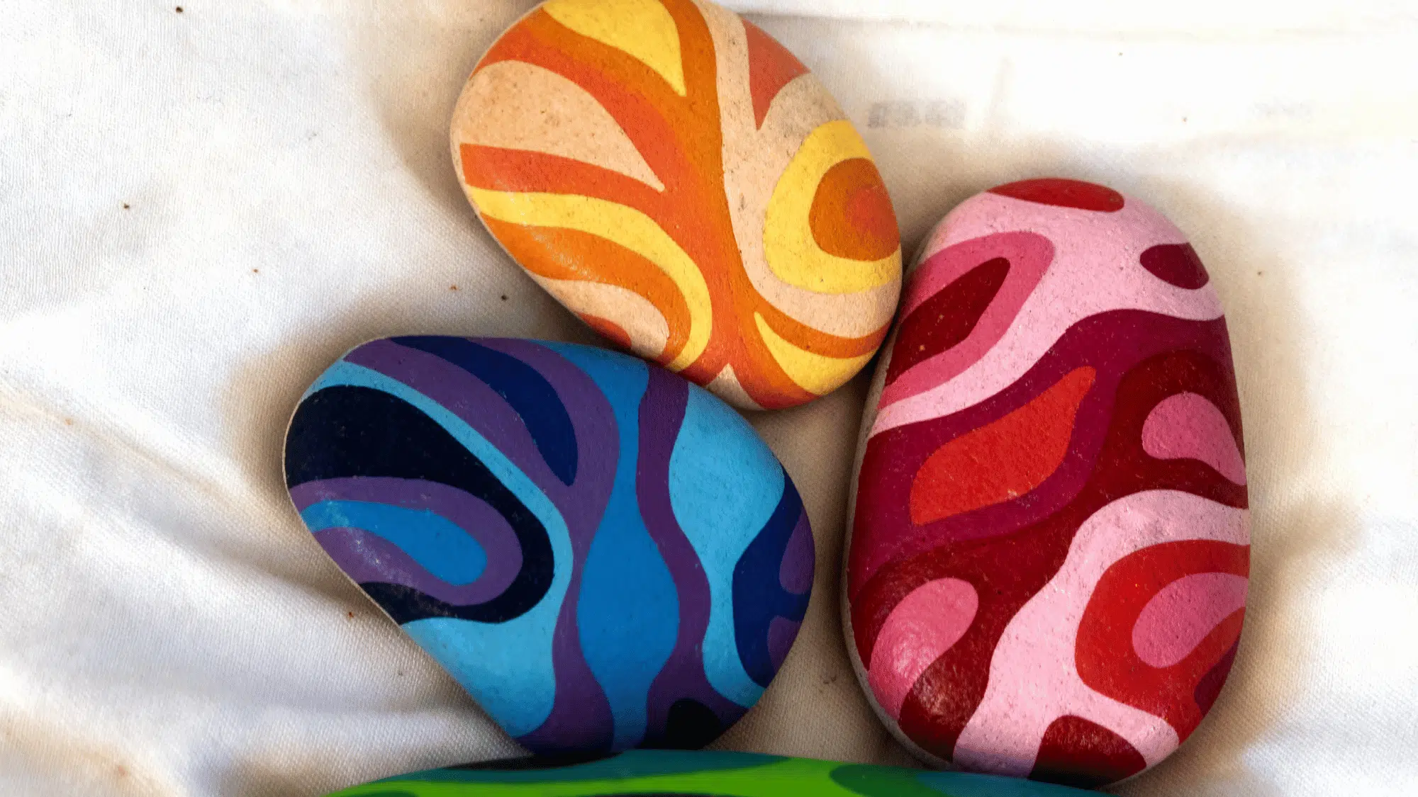 Colorful abstract wavy pattern painted rocks
