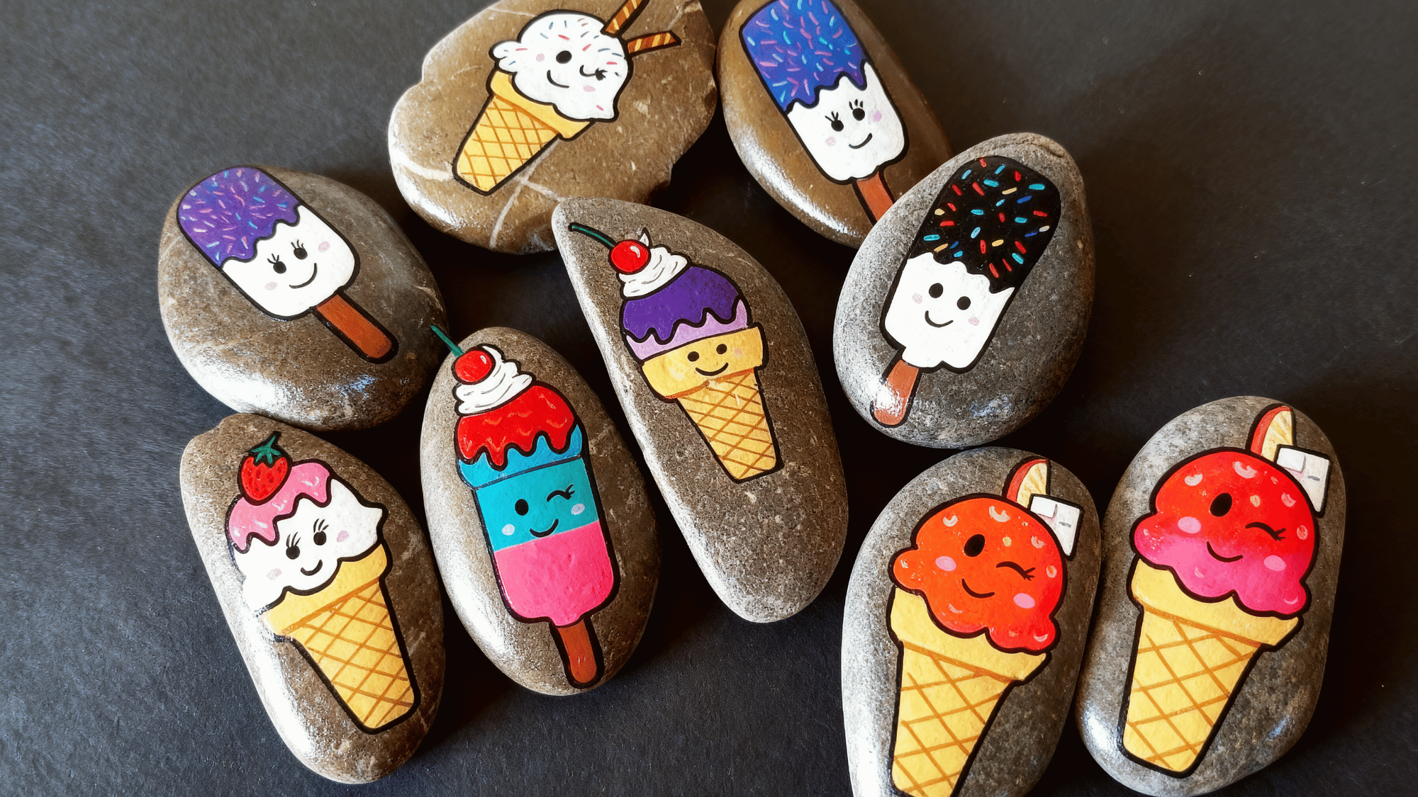 Colorful ice cream and popsicle painted rocks with happy faces.