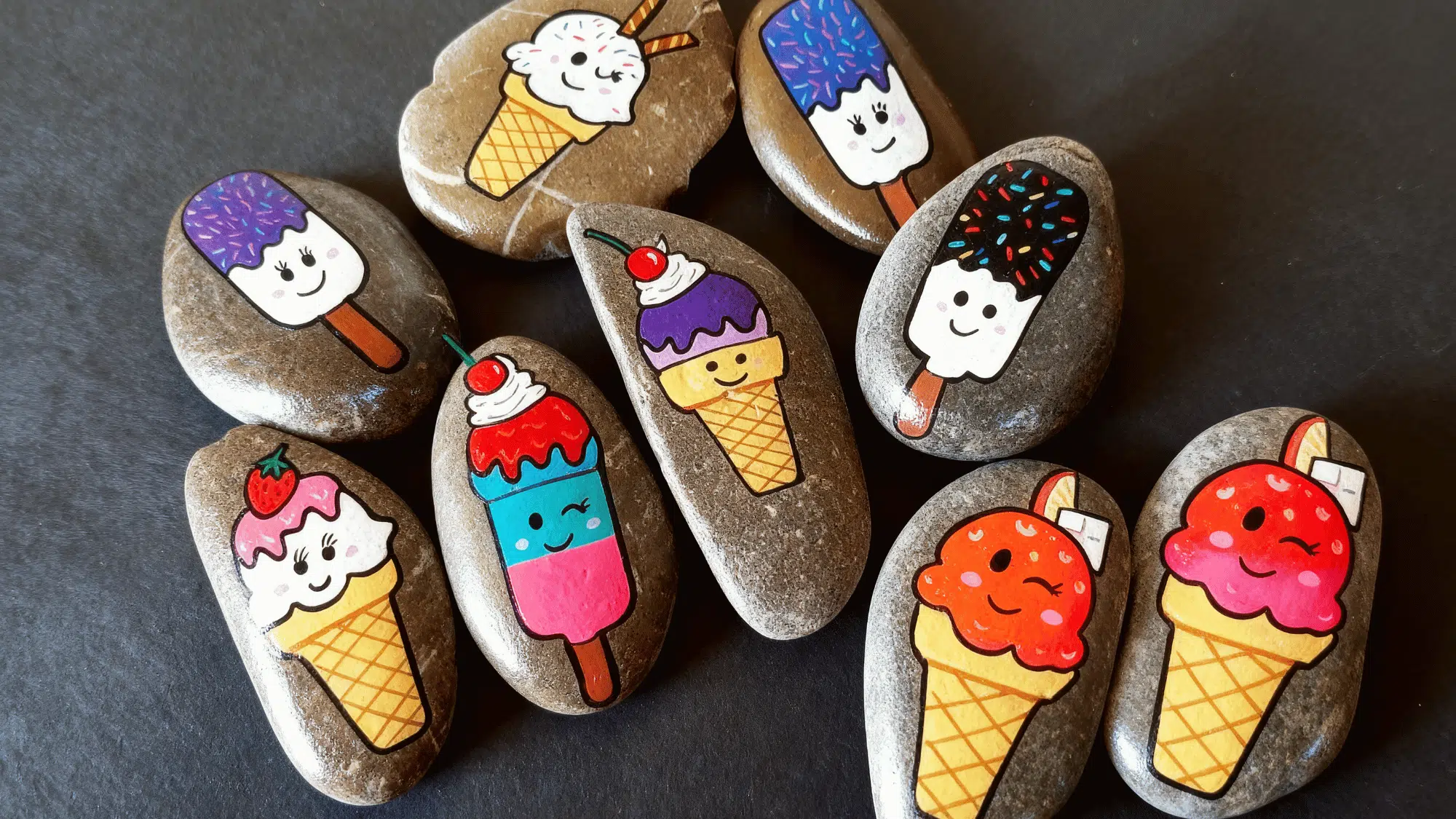 Colorful ice cream and popsicle painted rocks with happy faces.