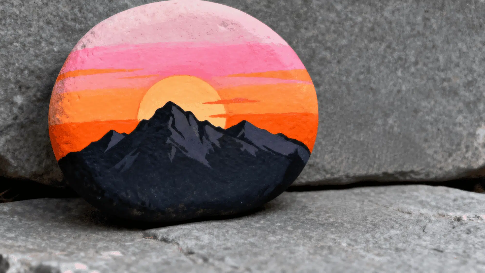 Sunset mountain landscape and Earth painted on smooth rocks