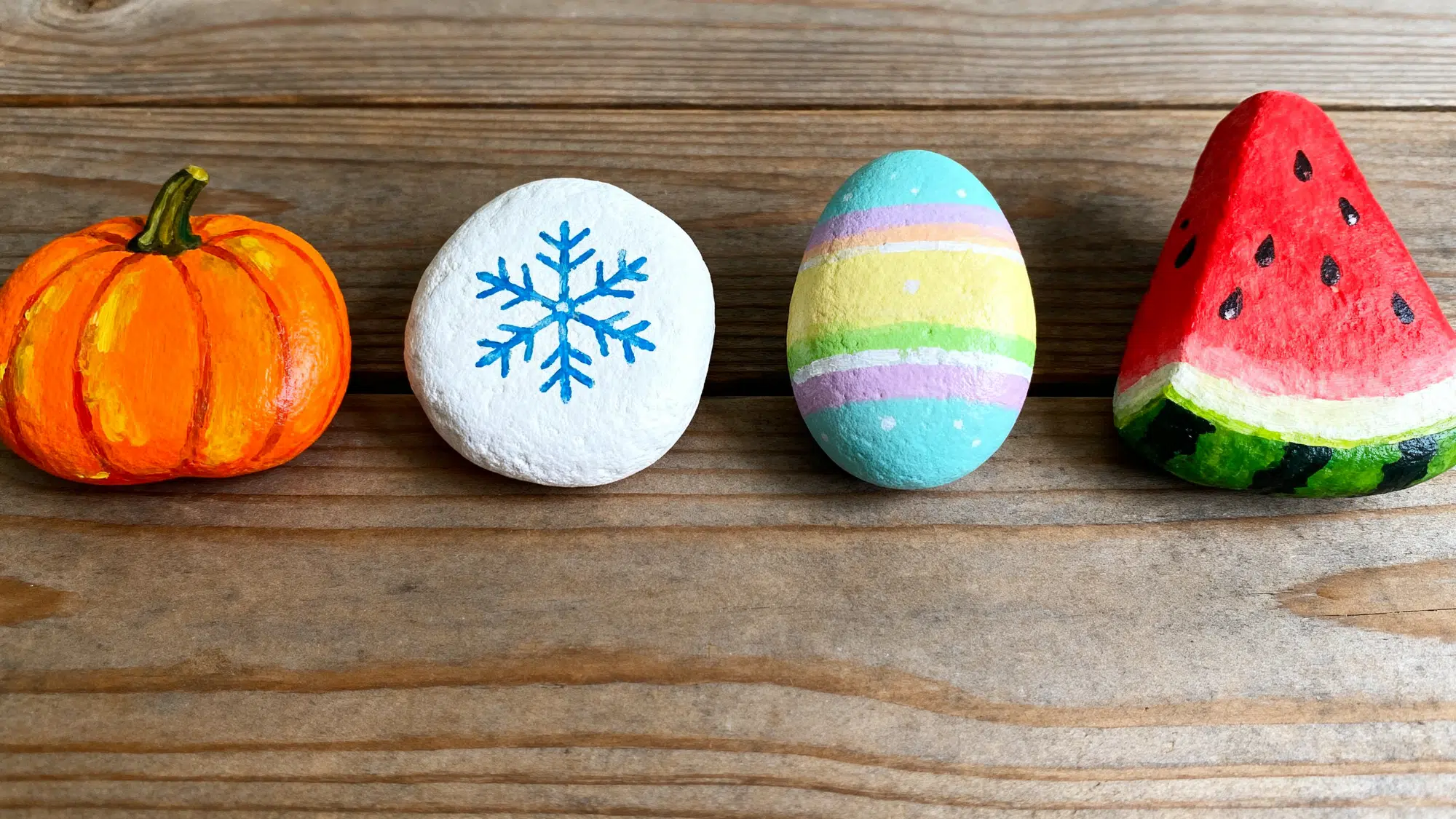 Four seasonal painted rocks pumpkin snowflake egg and watermelon
