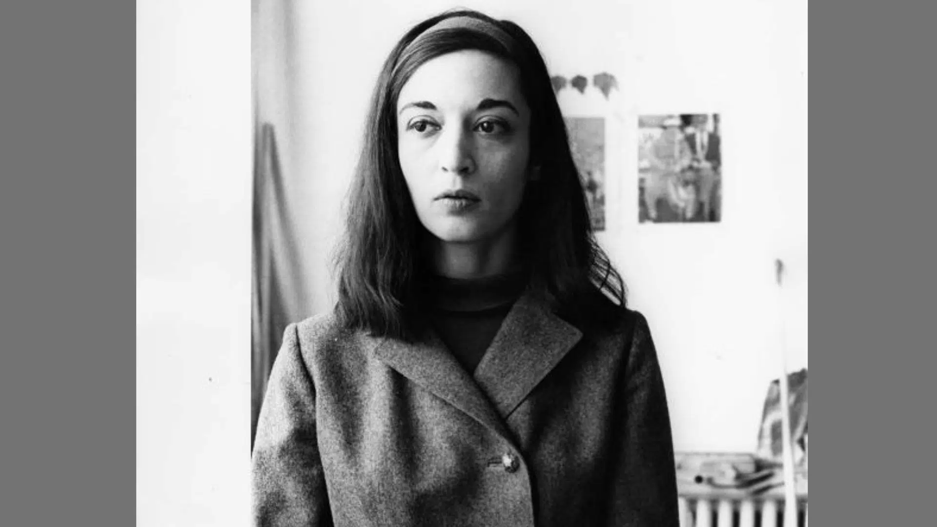 a black-and-white vintage portrait of a woman with a headband wearing a tailored buttoned coat