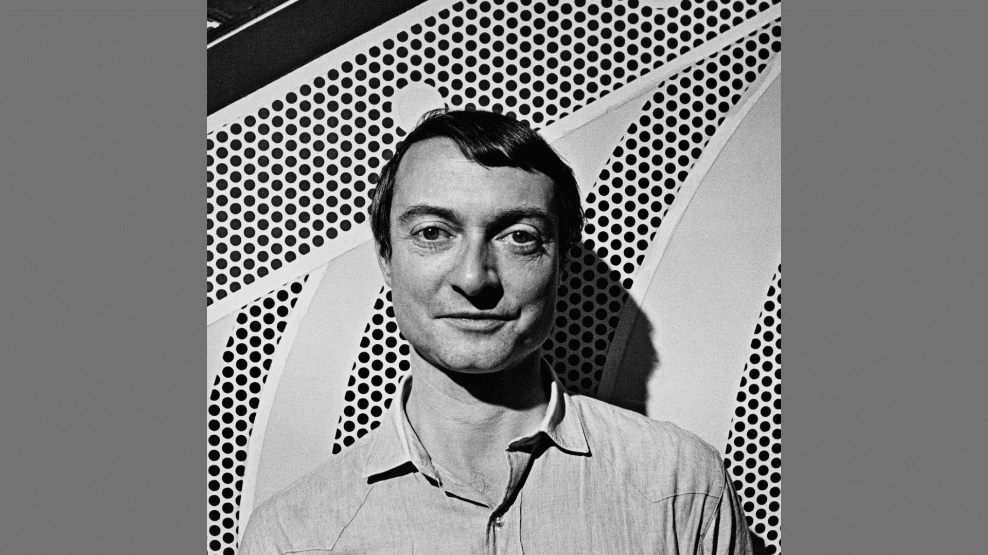black and white portrait of a man in a collared shirt posing before a graphic pop art pattern background