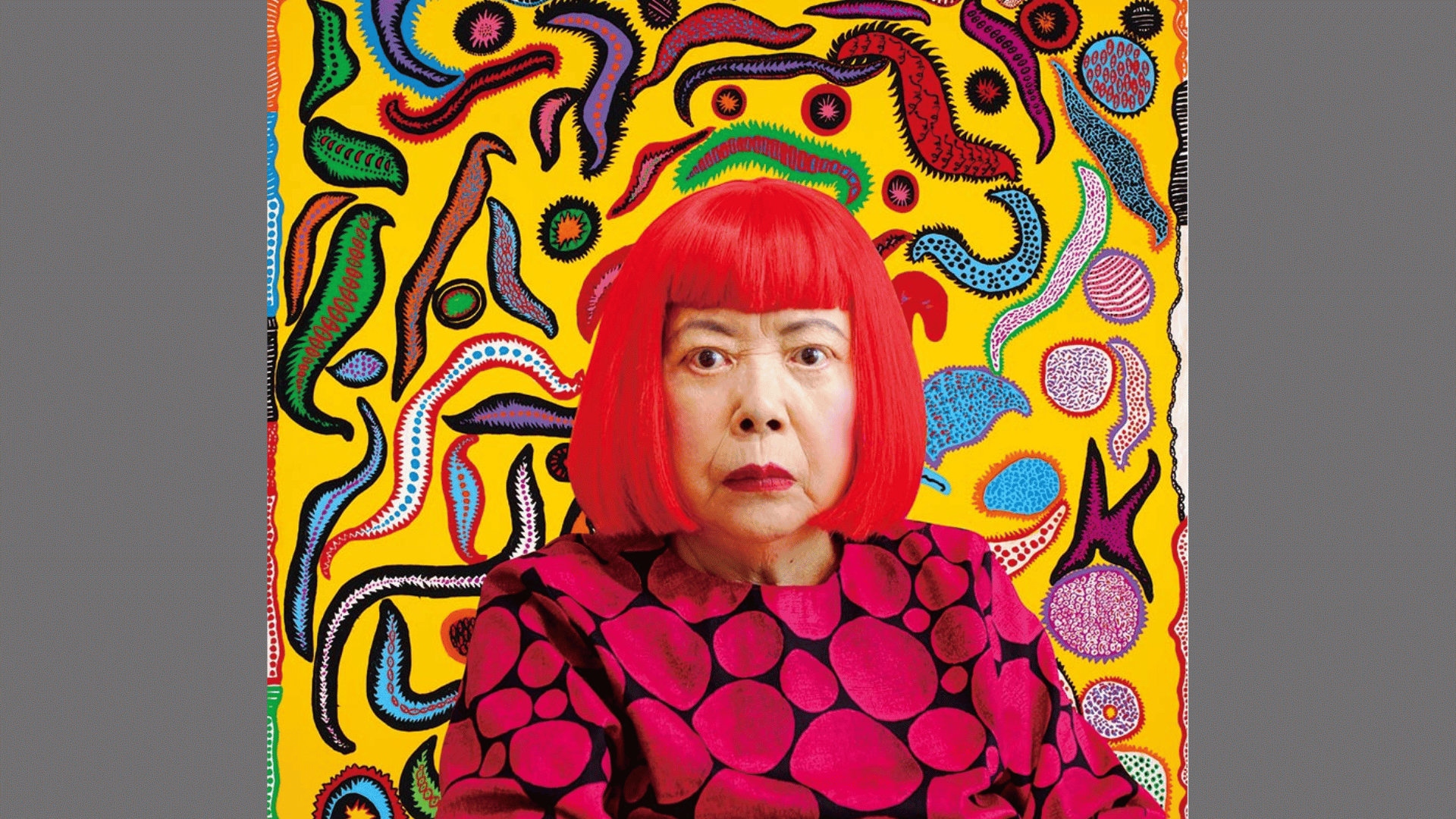 portrait of artist Yayoi Kusama in a red wig and polka dot shirt with a vibrant yellow abstract background