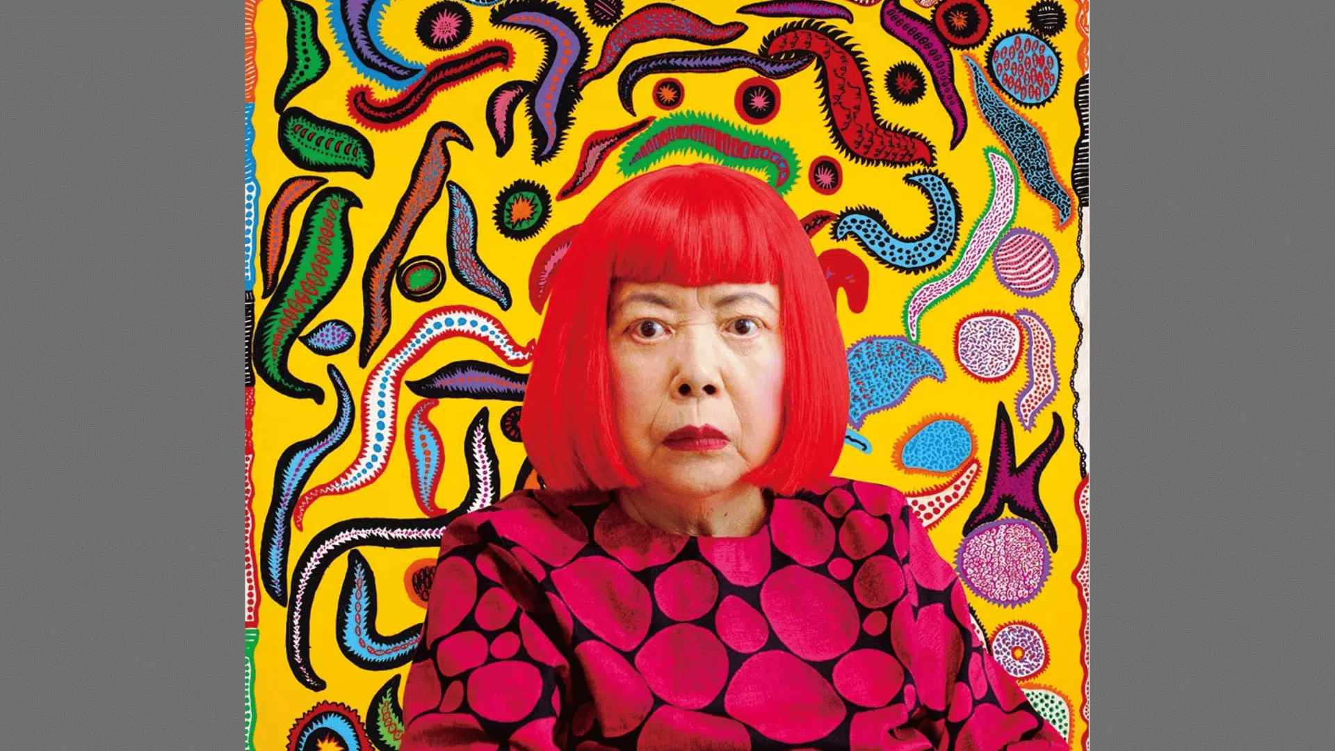 portrait of artist Yayoi Kusama in a red wig and polka dot shirt with a vibrant yellow abstract background
