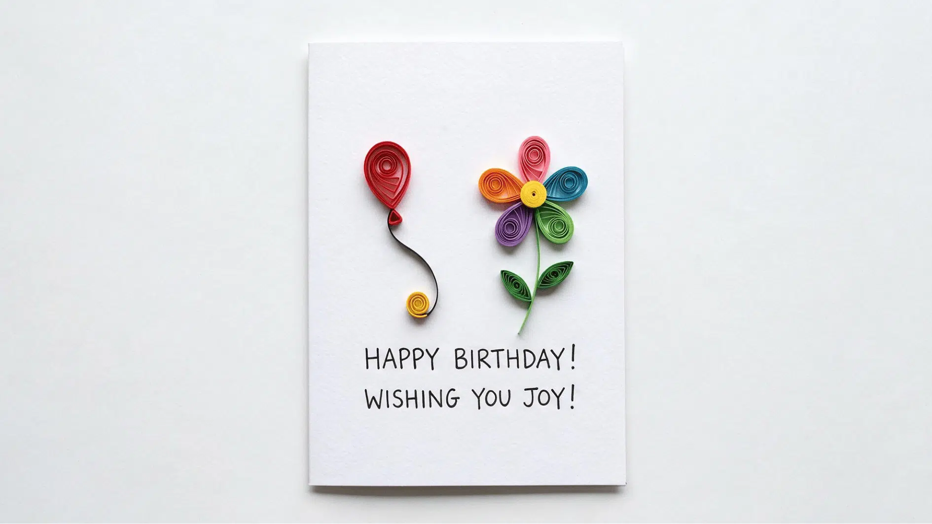 birthday card with quilled paper red balloon and rainbow colored flower and handwritten greeting