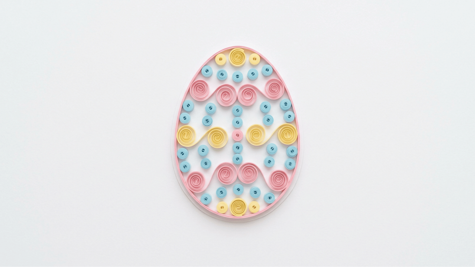 quilled paper easter egg decorated with pink blue and yellow spiral patterns on white background