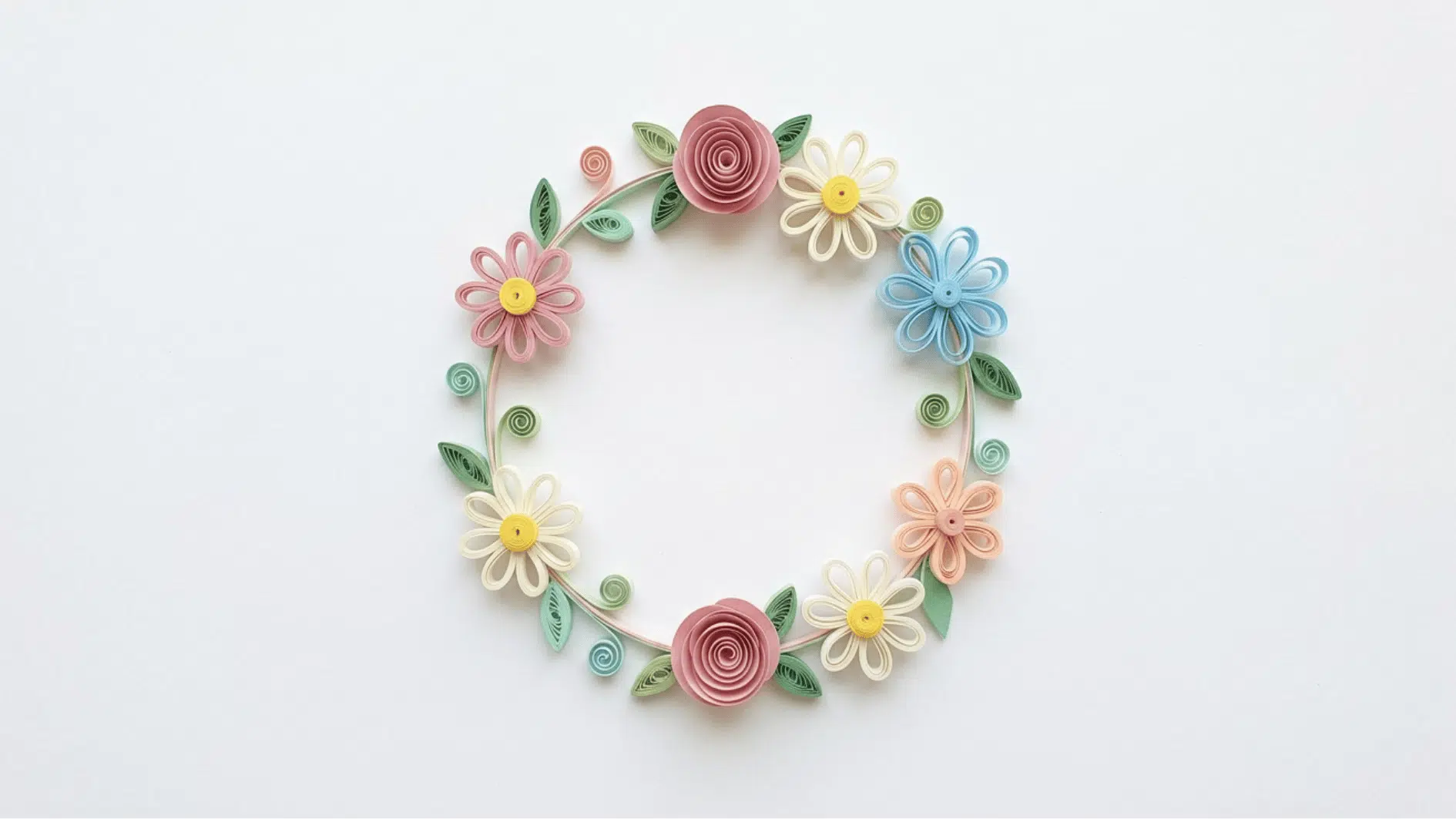 quilled paper floral wreath with roses daisies and blue flowers in a circular arrangement on white background