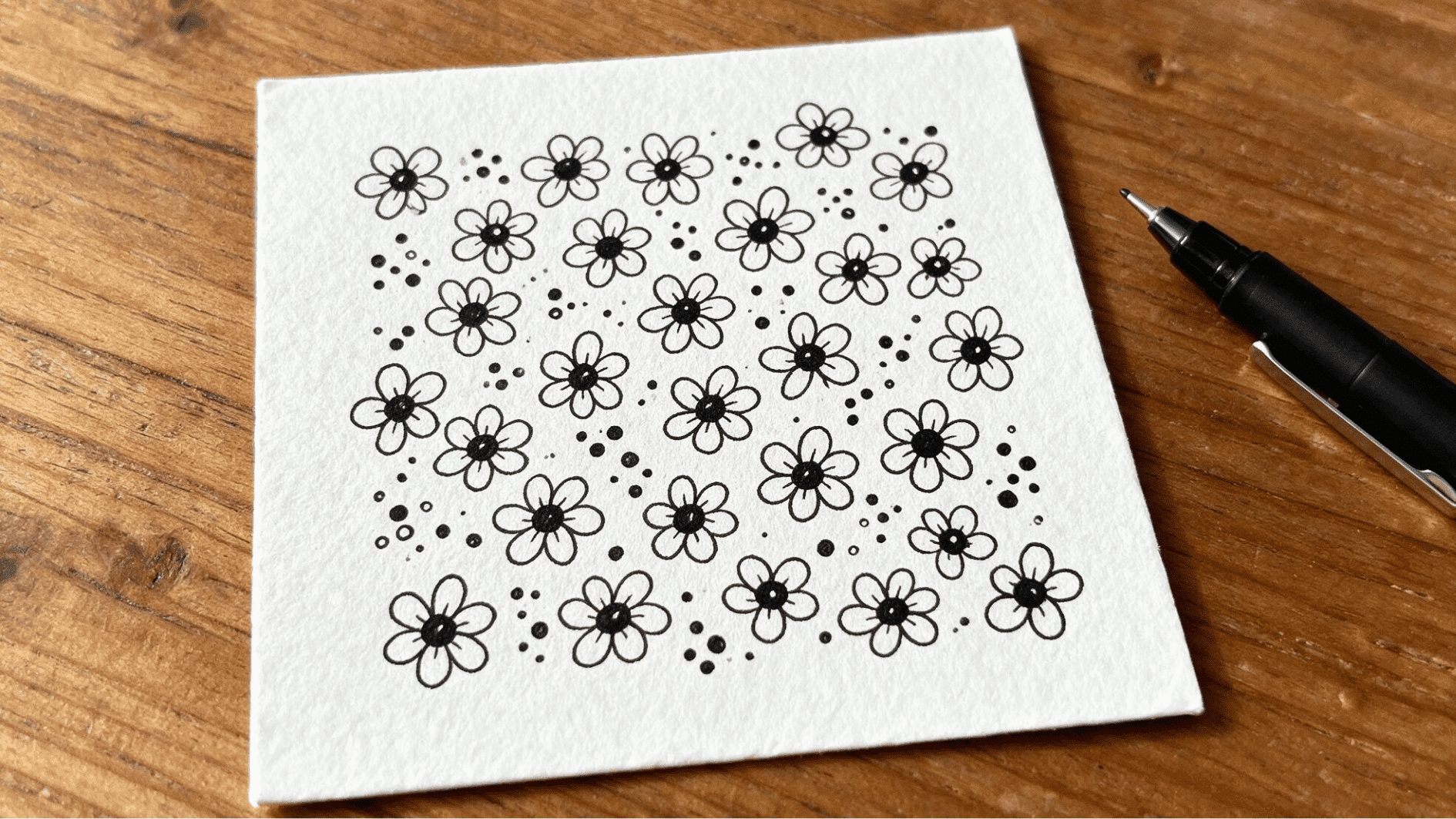 flower dot zentangle pattern with simple petal shapes and scattered dots covering a white paper tile