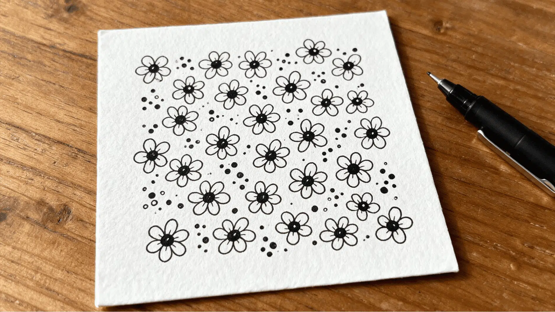 flower dot zentangle pattern with simple petal shapes and scattered dots covering a white paper tile