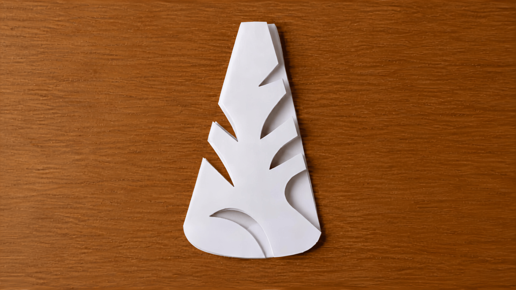 folded paper with geometric shapes and curved cuts along the edges