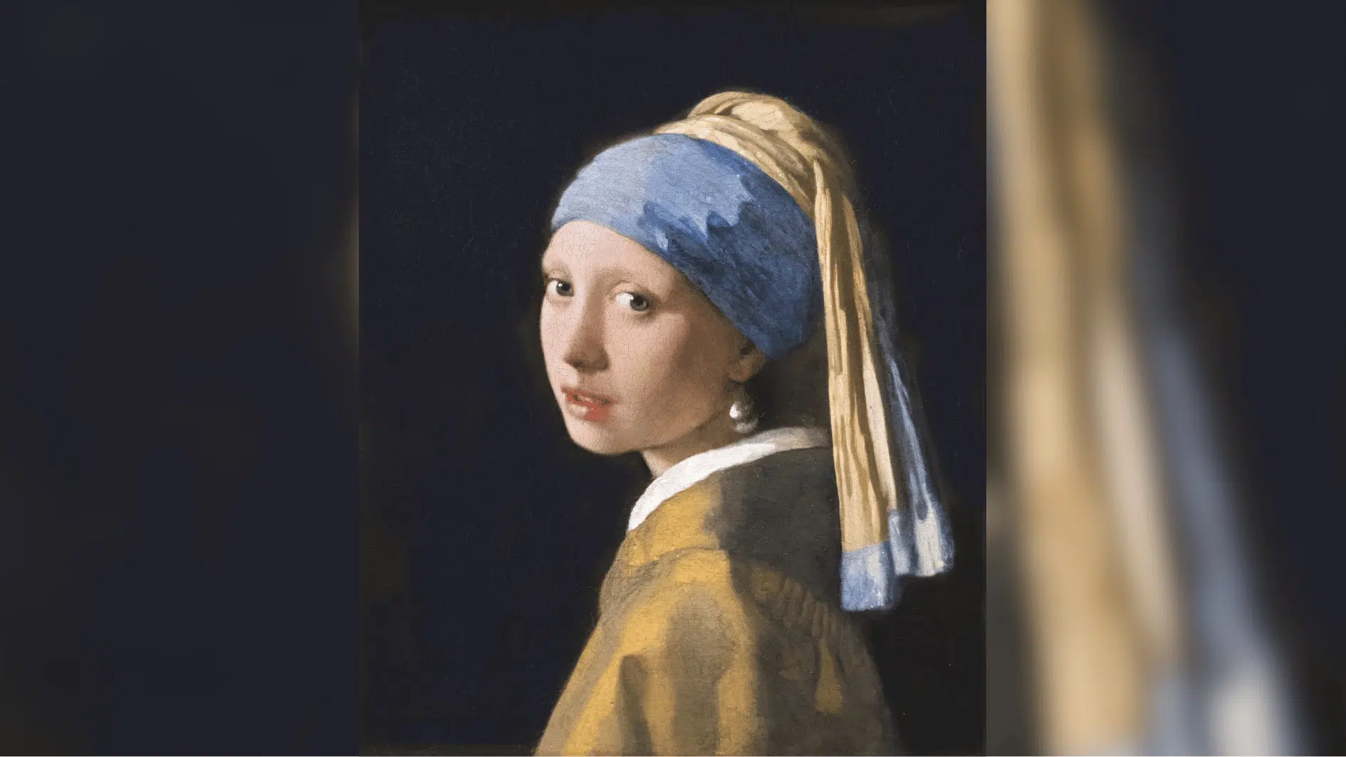 girl with a pearl earring looking over her shoulder against a dark background