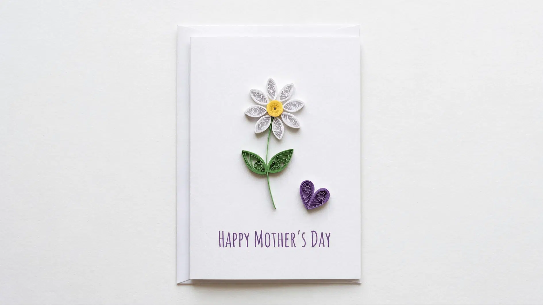 mothers day card with quilled paper white daisy green leaves and purple heart on white background