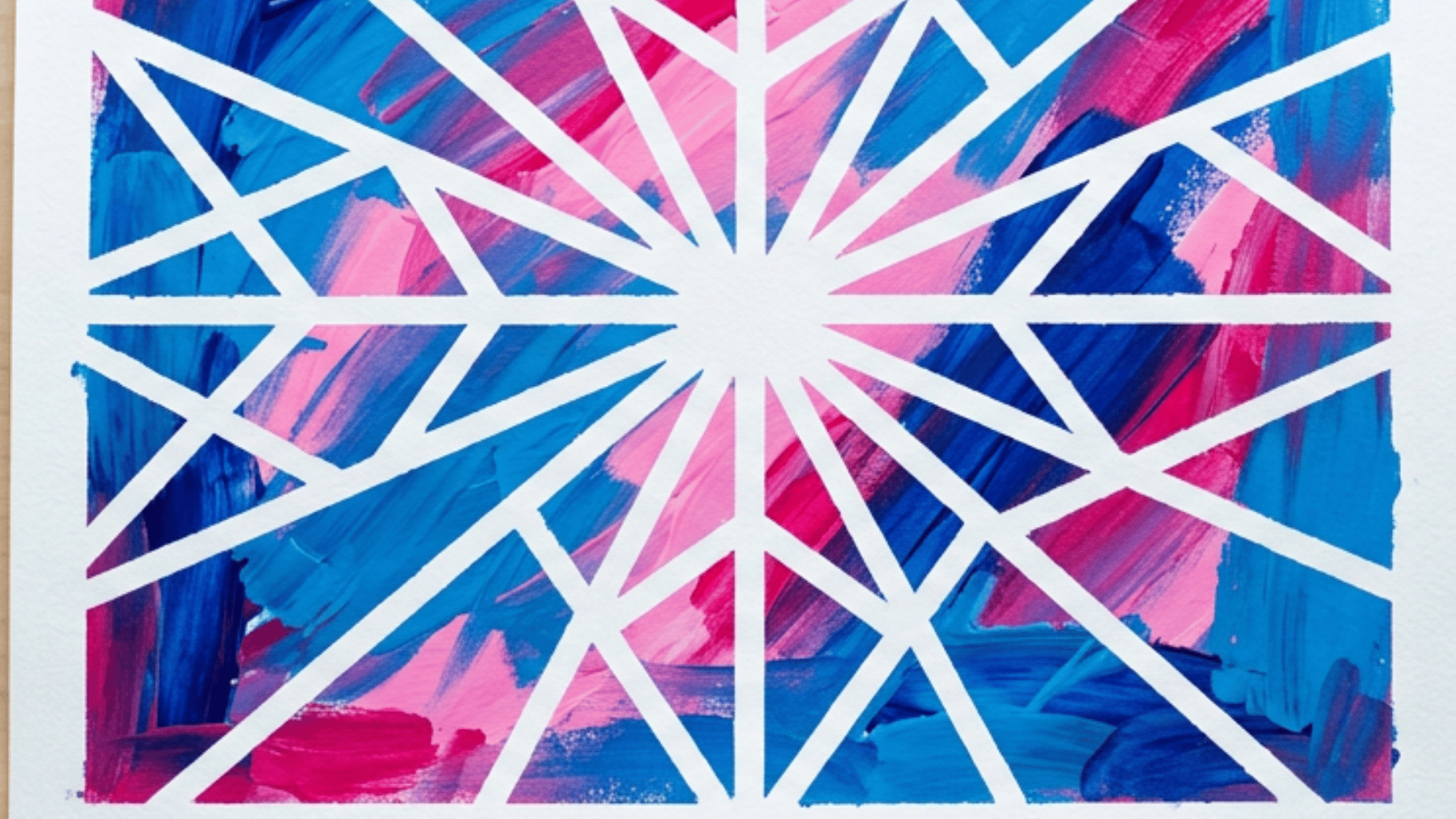 painters tape resist art with a geometric star pattern in blue and pink paint