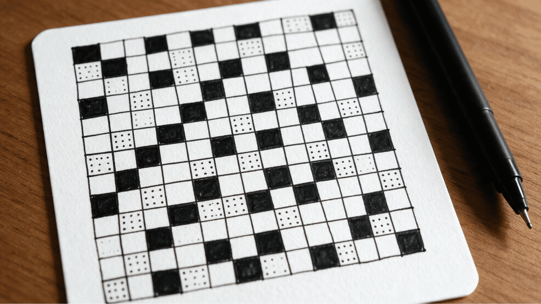 print zentangle pattern with hand drawn grid squares, black fills, and dotted details on a white tile