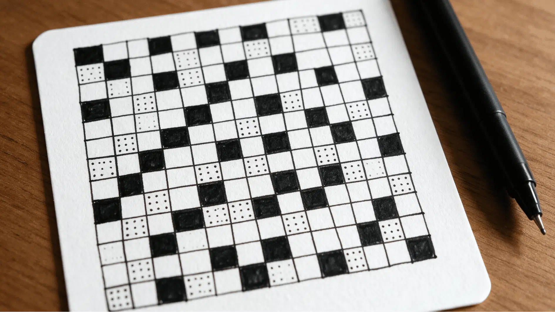 print zentangle pattern with hand drawn grid squares, black fills, and dotted details on a white tile