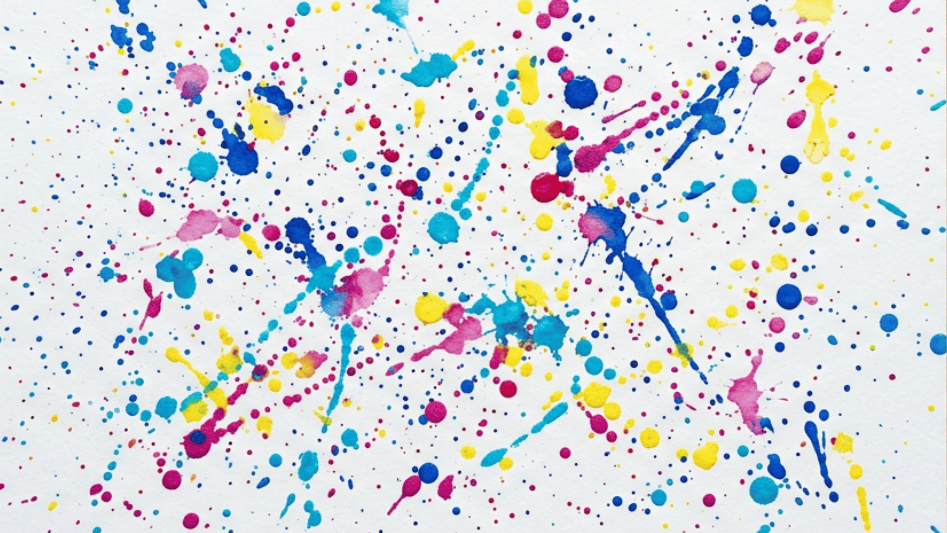 splatter painting with colorful pink blue and yellow paint droplets scattered on white paper