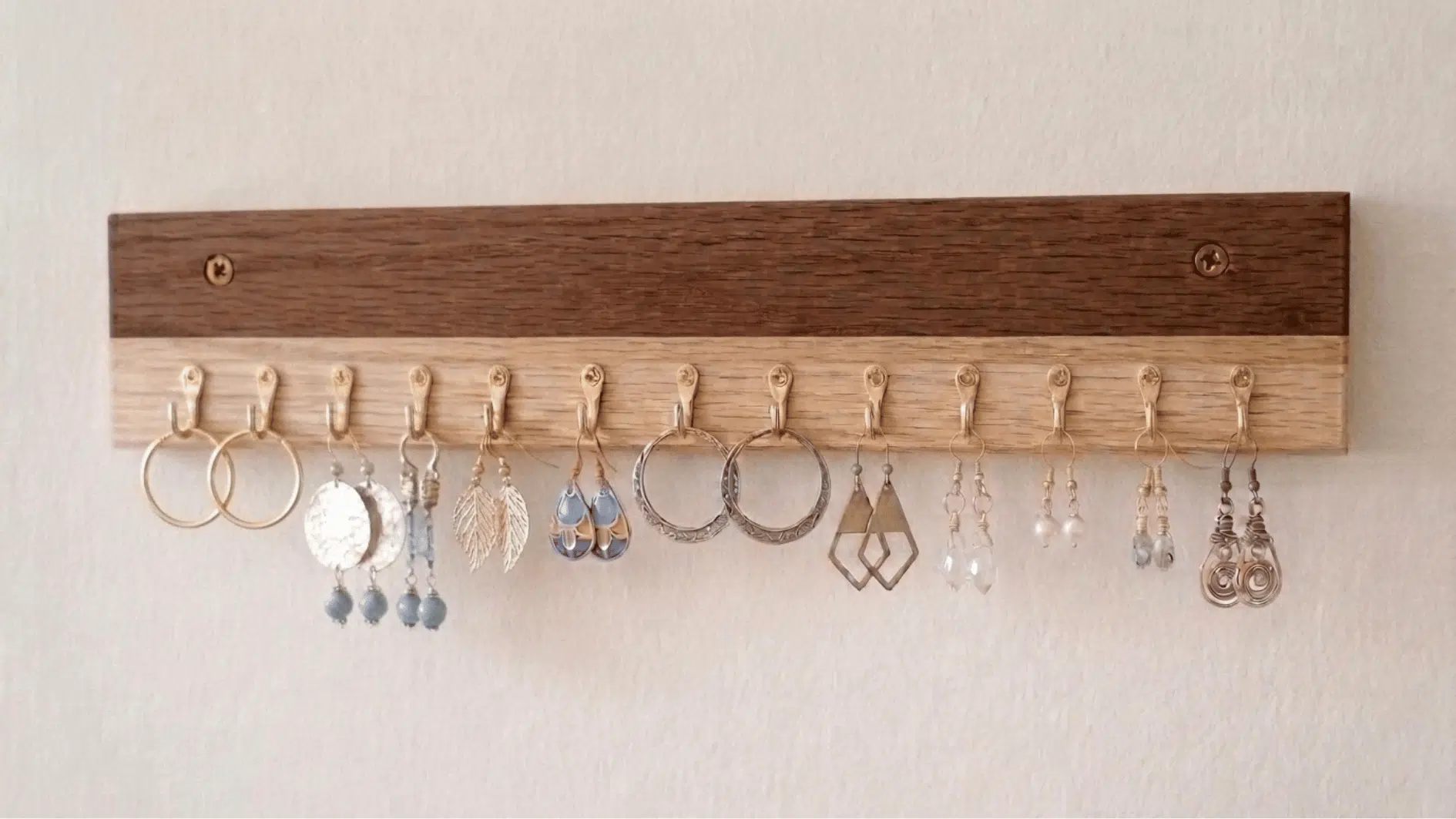 wall-mounted hook display holding dangle earrings and hoop earrings
