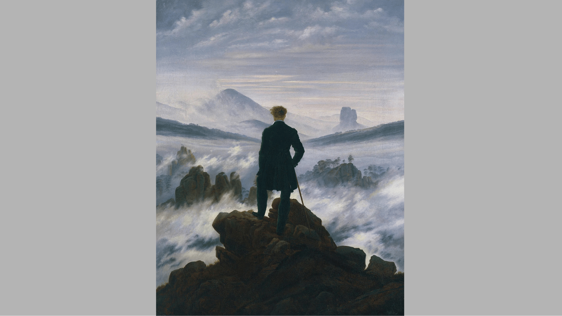 a lone man in a dark coat stands on a rocky peak, back to us, gazing over a vast sea of fog and mountains